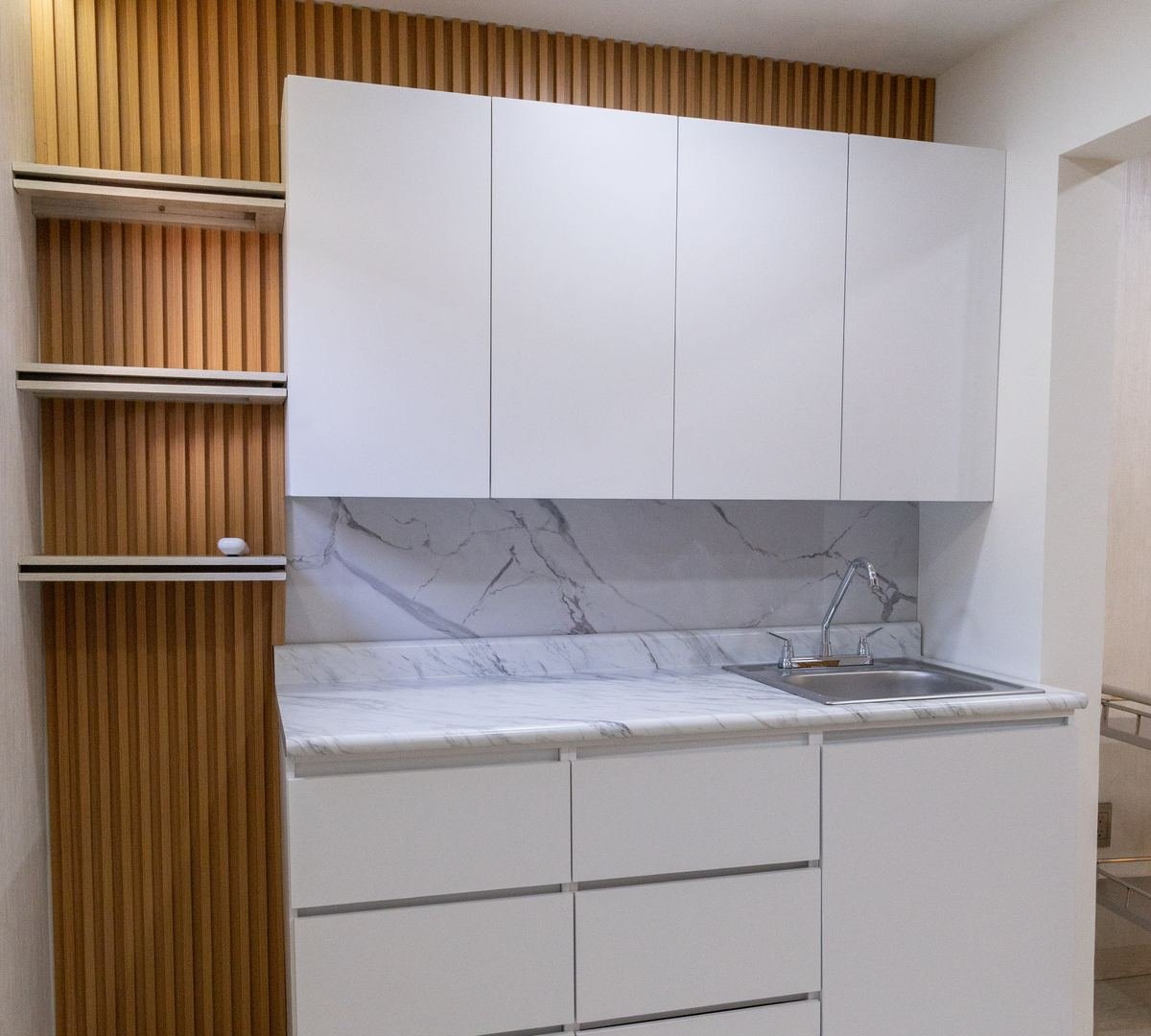 Cocineta a medida con cubierta de mármol y muro de lambrín, fabricada por Decora